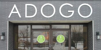 A brick building with a sign that says adogo on it.