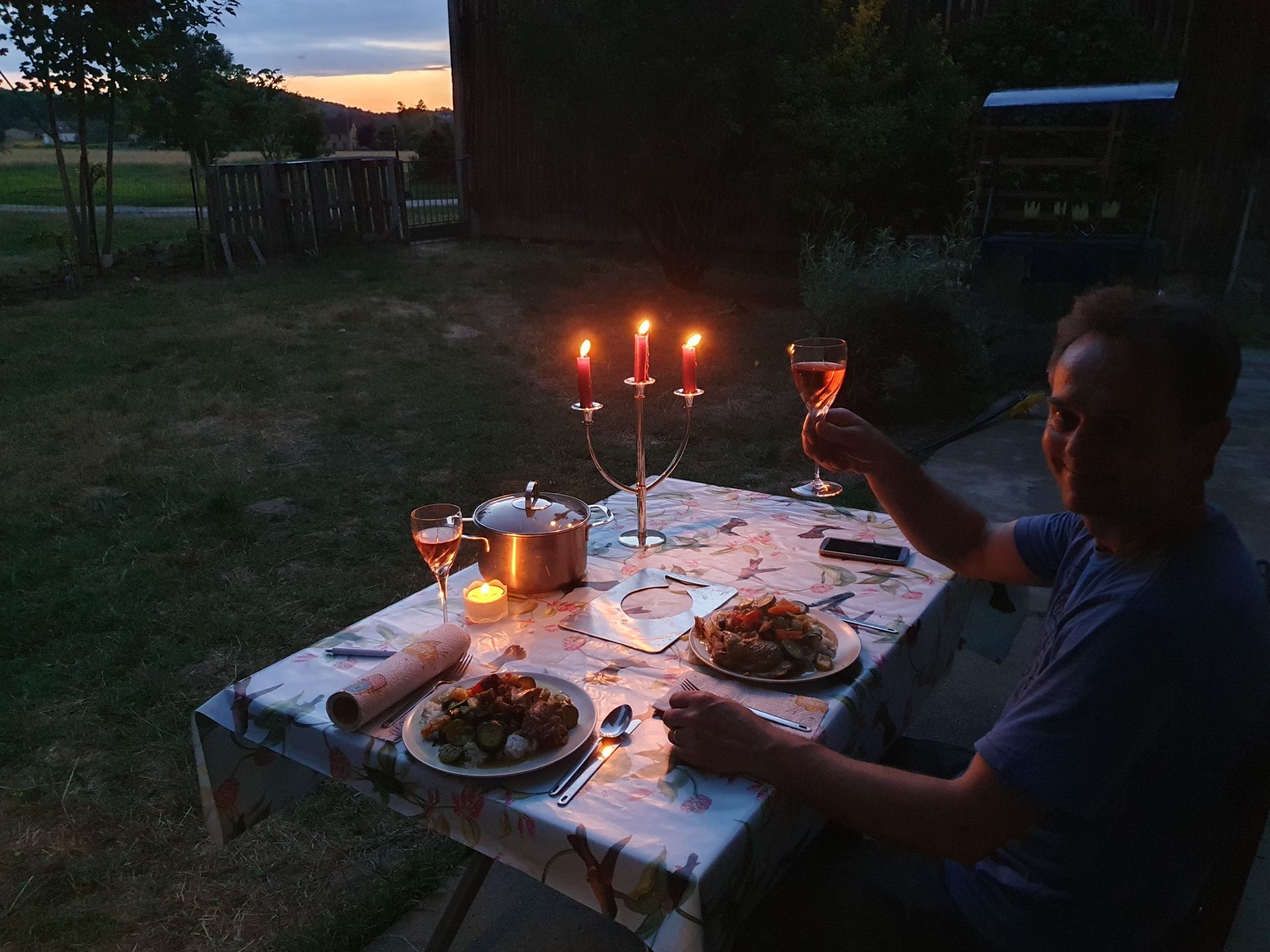 Un homme est assis à une table avec des bougies et des assiettes de nourriture