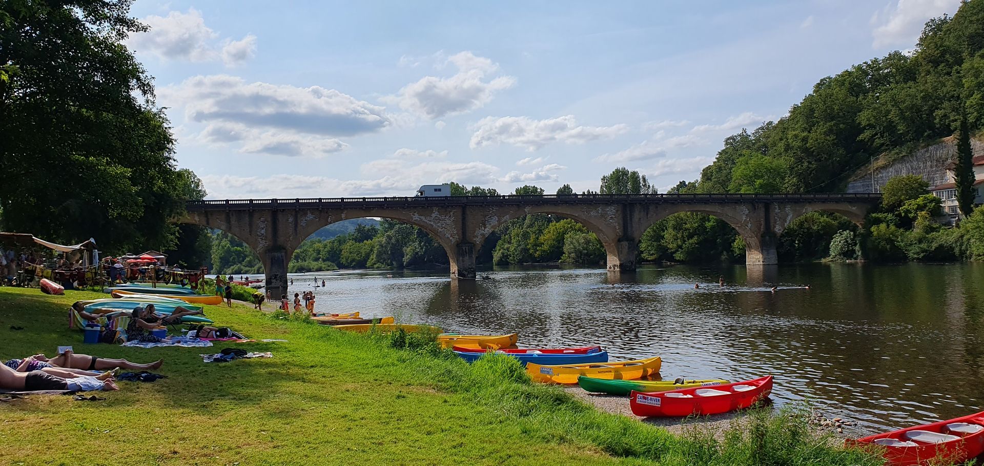 Un pont sur une rivière avec des kayaks au premier plan
