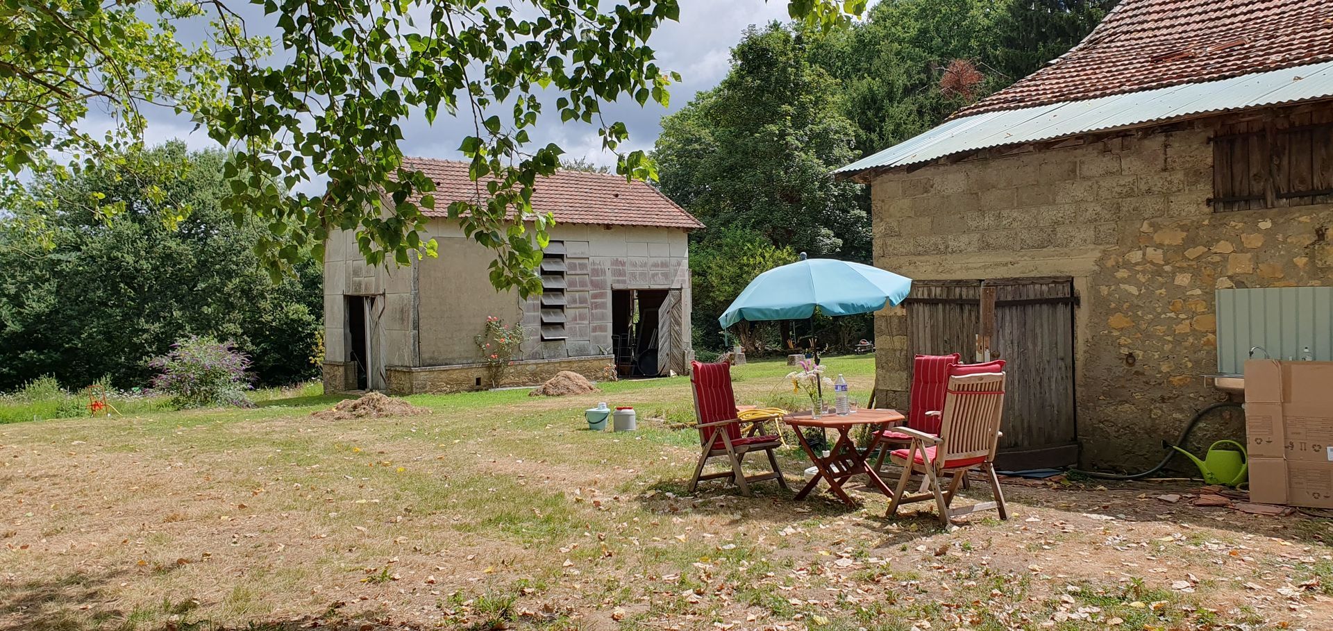 Une table et des chaises sont placées devant un bâtiment en pierre.