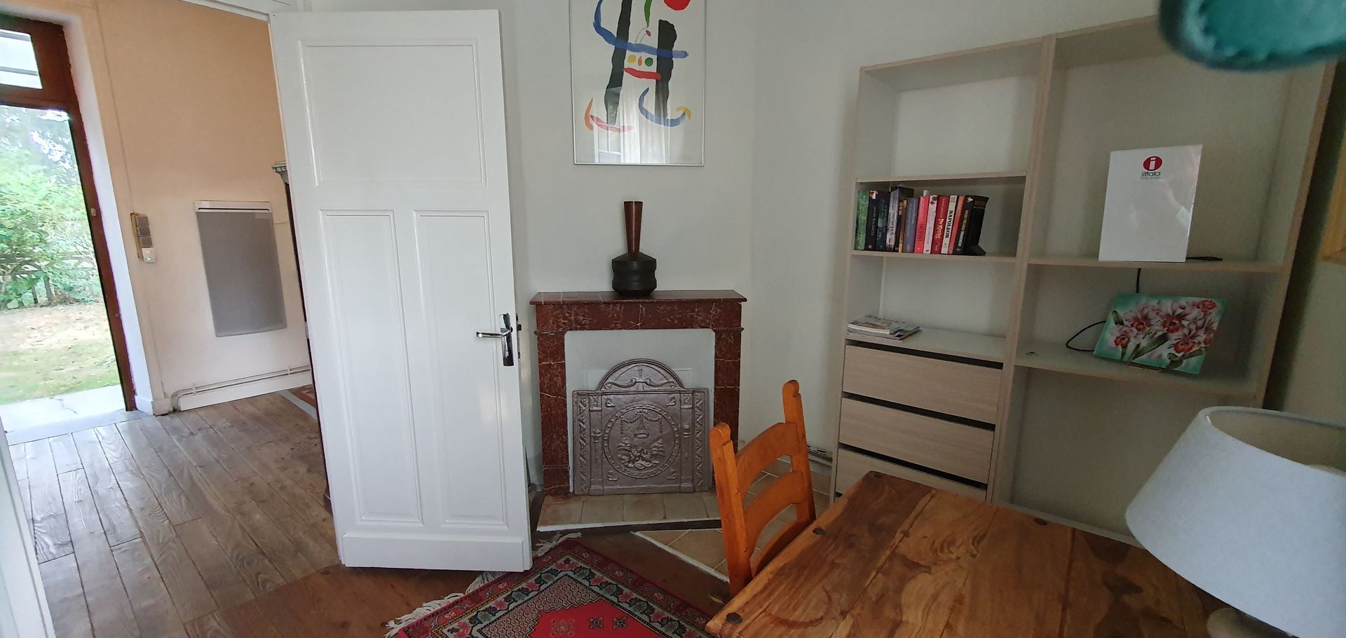 A room with a table and chair and a fireplace