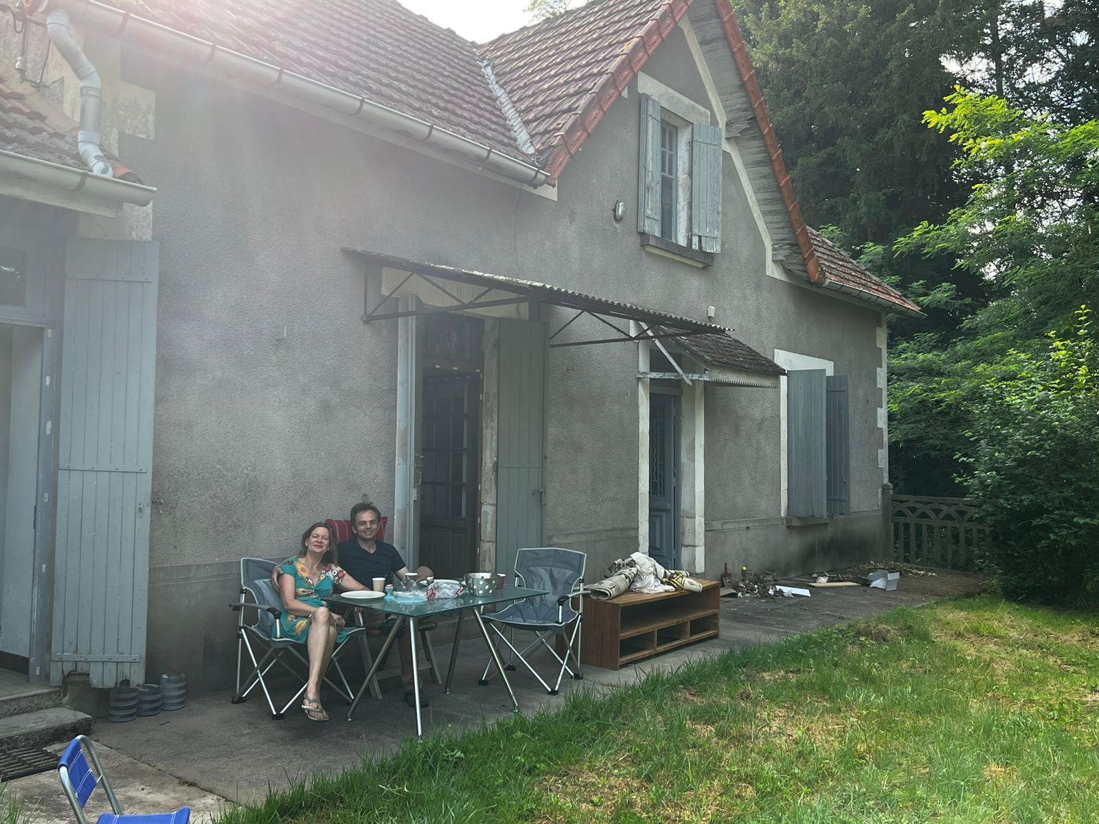Een man en een vrouw zitten buiten voor een huis