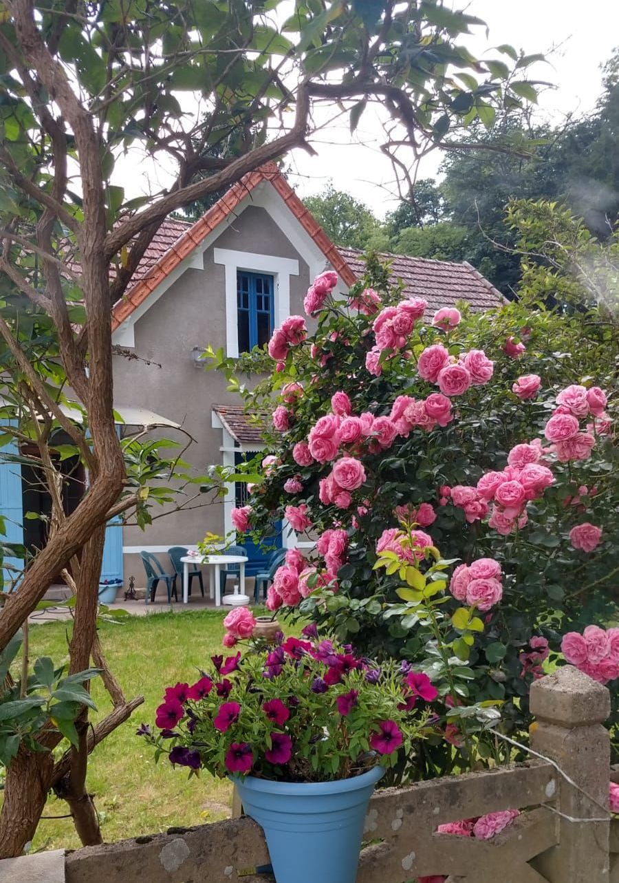 Une maison avec des roses devant