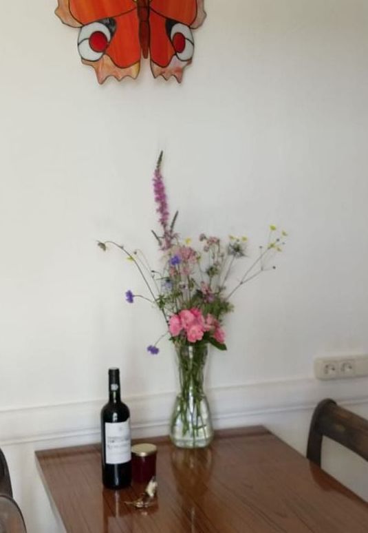 Une table avec un vase de fleurs et une bouteille de vin