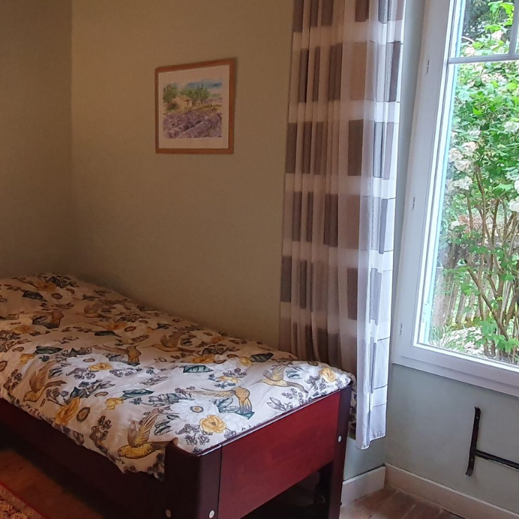 Een slaapkamer met twee eenpersoonsbedden en een nachtkastje
