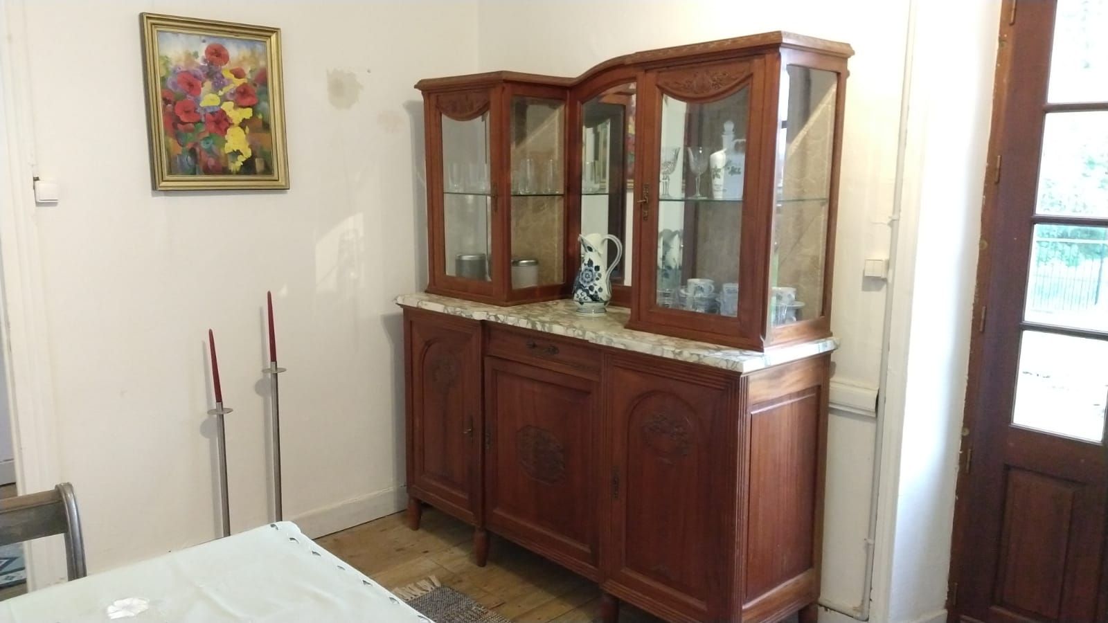 A room with woodstove with a table and chairs and a cabinet