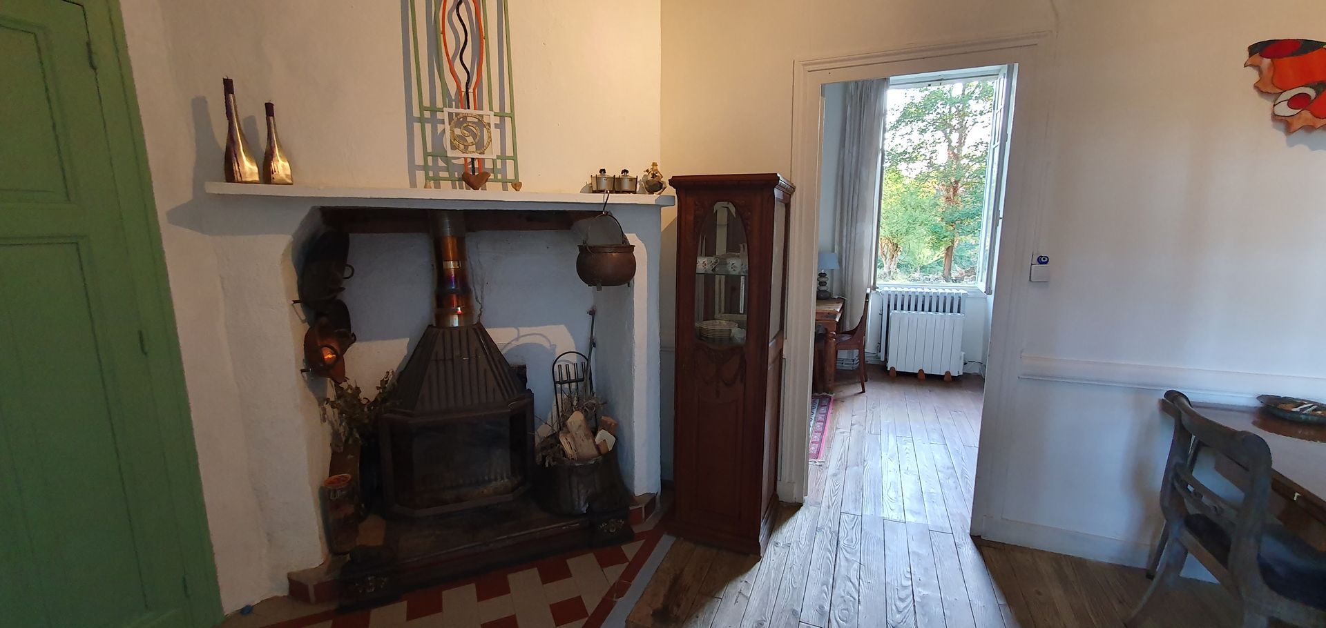 A living room with a flat screen tv on a stand and broquante cabinet