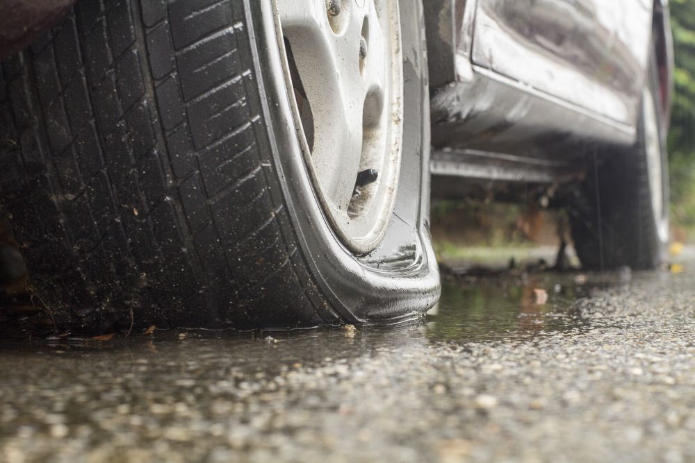 Close-up of Flat Tyre on a Wet Road