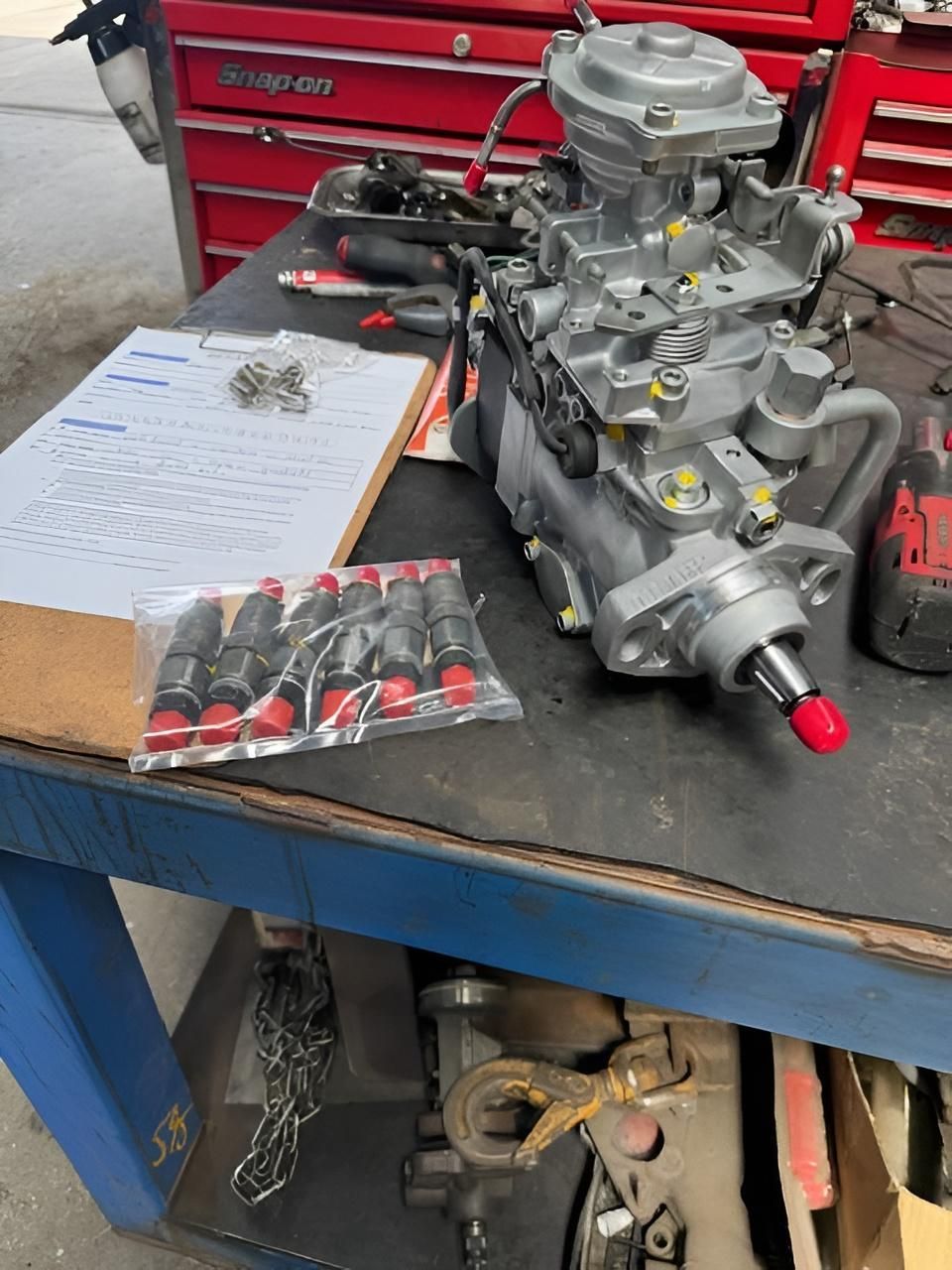 Diesel fuel injection pump and injectors stripped for testing and repair at a mechanic workshop in Nowra