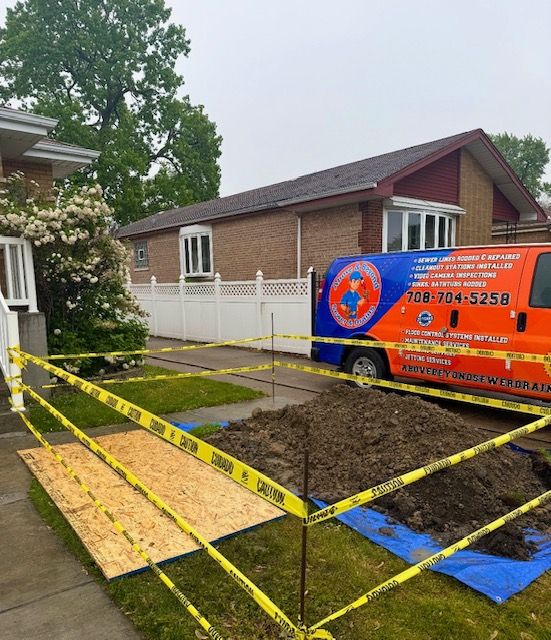 Orange service van beside taped-off muddy yard and walkway under construction in front of a house