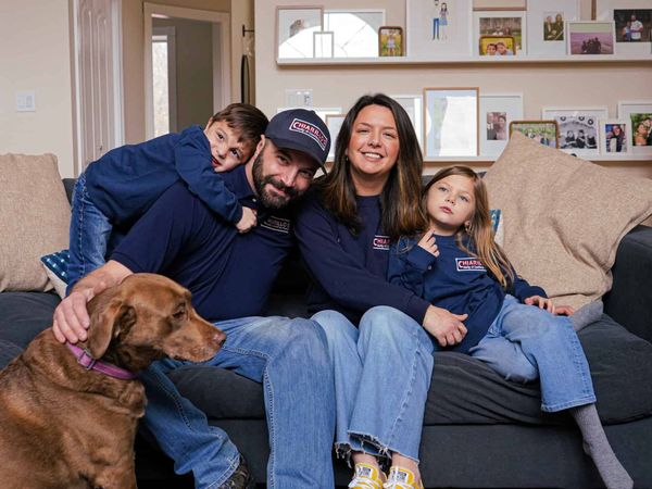A family is sitting on a couch with a dog.