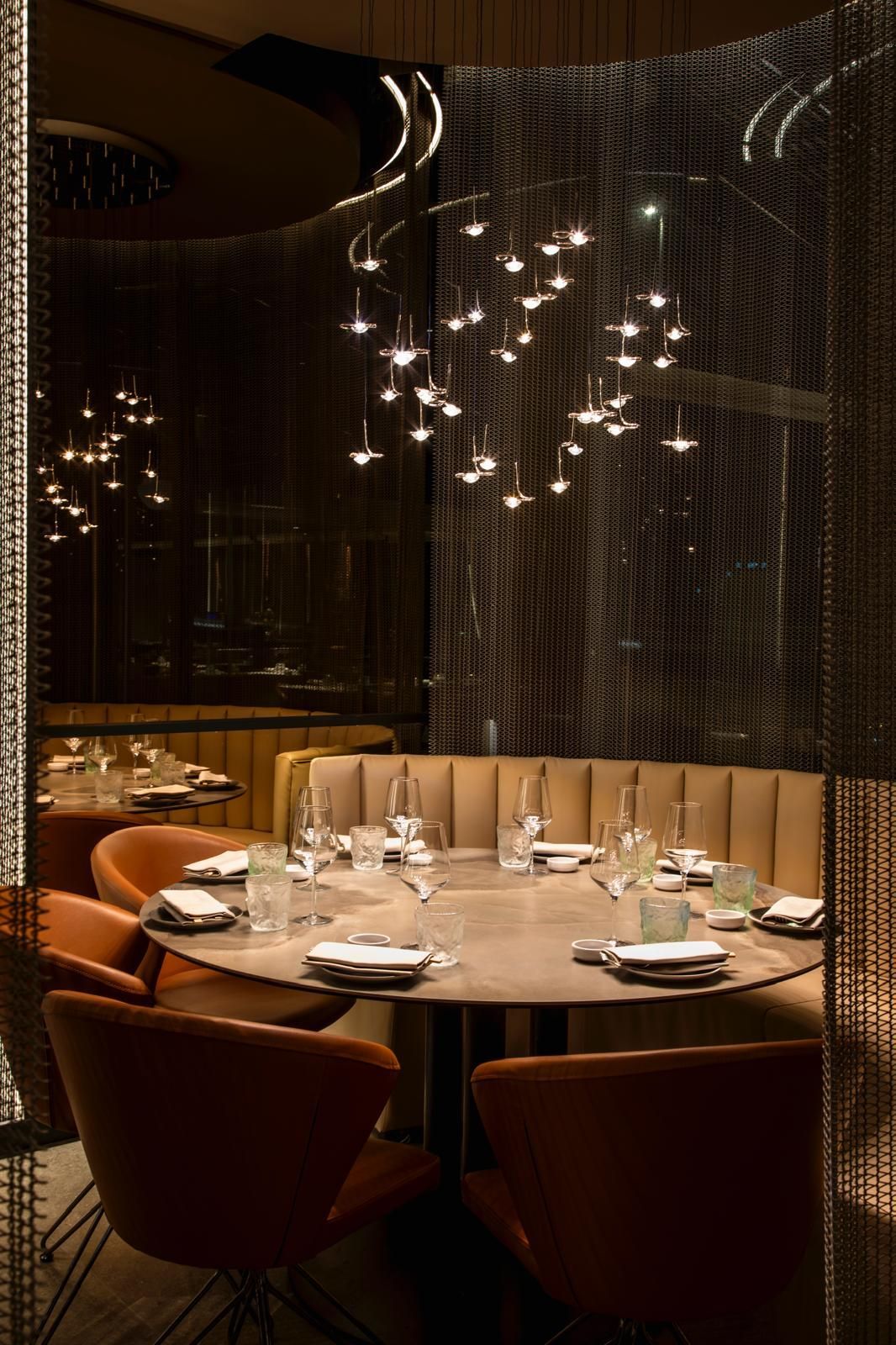 Un angolo di ristorante scarsamente illuminato con un tavolo rotondo
