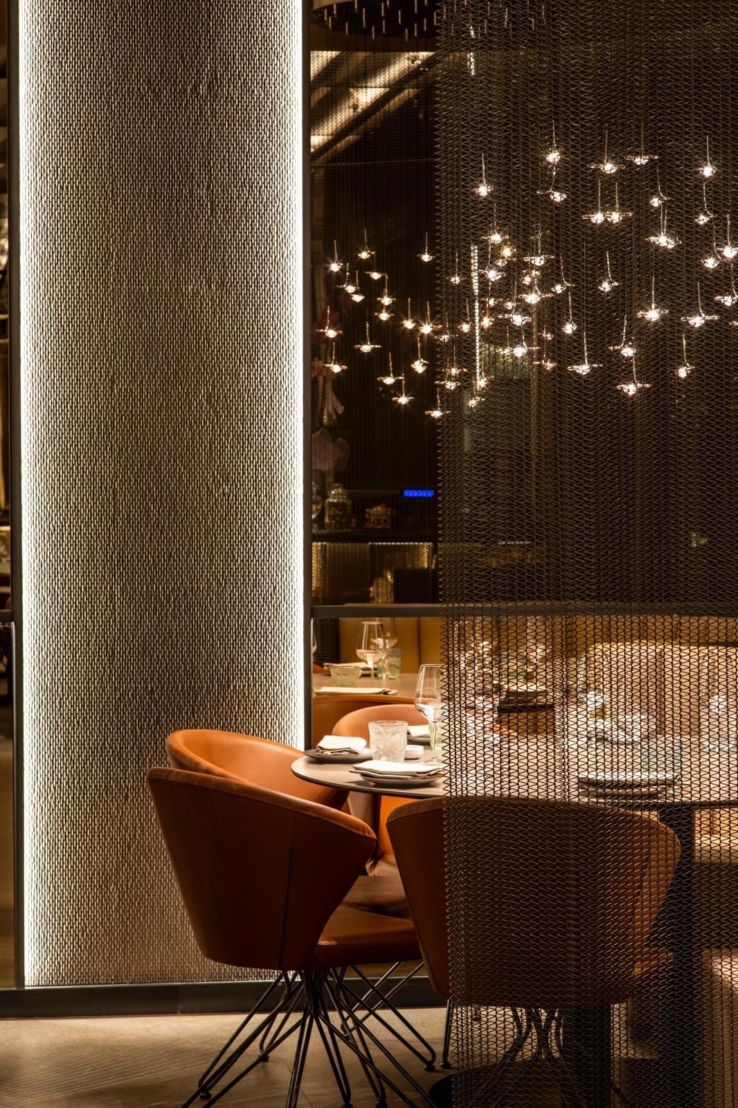 Una sala da pranzo di un ristorante elegante, con luci soffuse