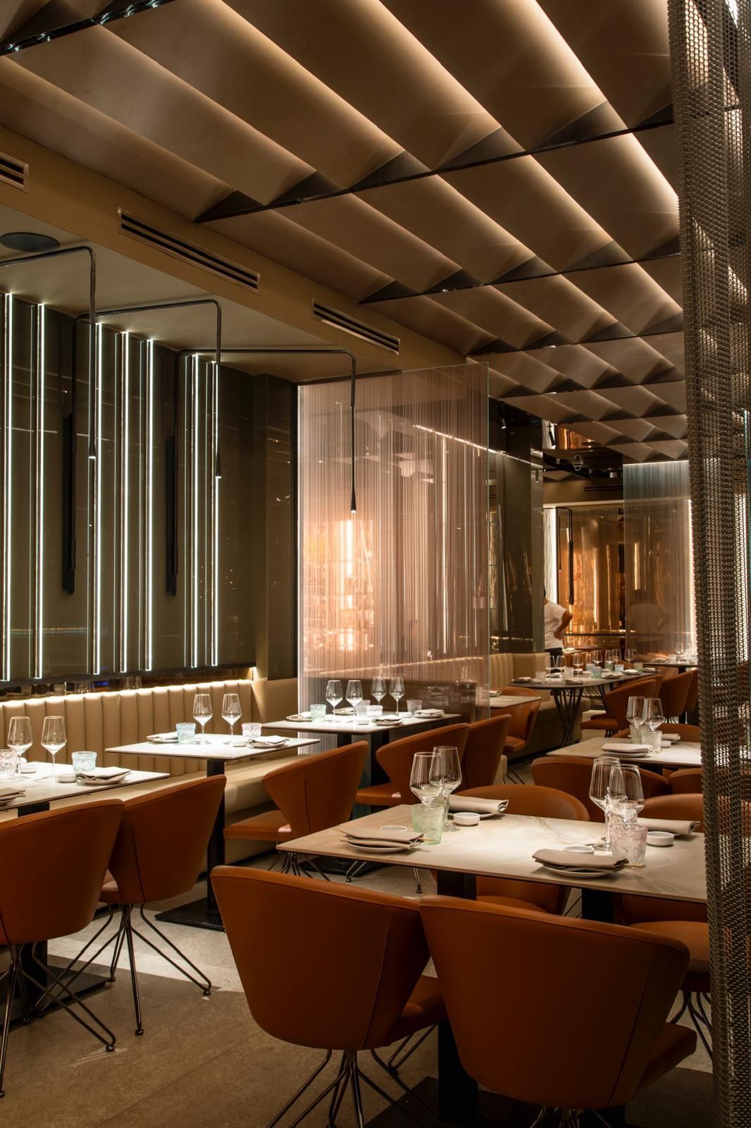 Interni moderni di un ristorante con sedie in pelle marrone, tavoli bianchi