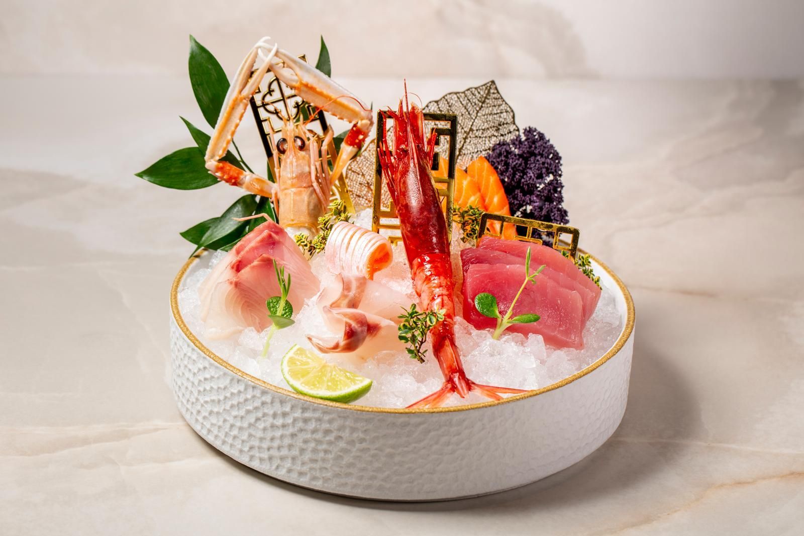 Piatto misto di sashimi servito su un letto di ghiaccio in una ciotola bianca dalla superficie ruvida
