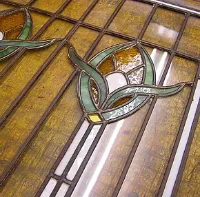 A close up of a stained glass window with a flower design on it.