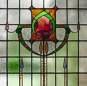A close up of a stained glass window with a flower design on it.