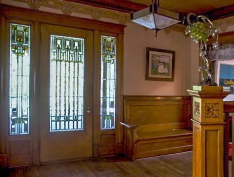 A room with a bench and a door with stained glass windows