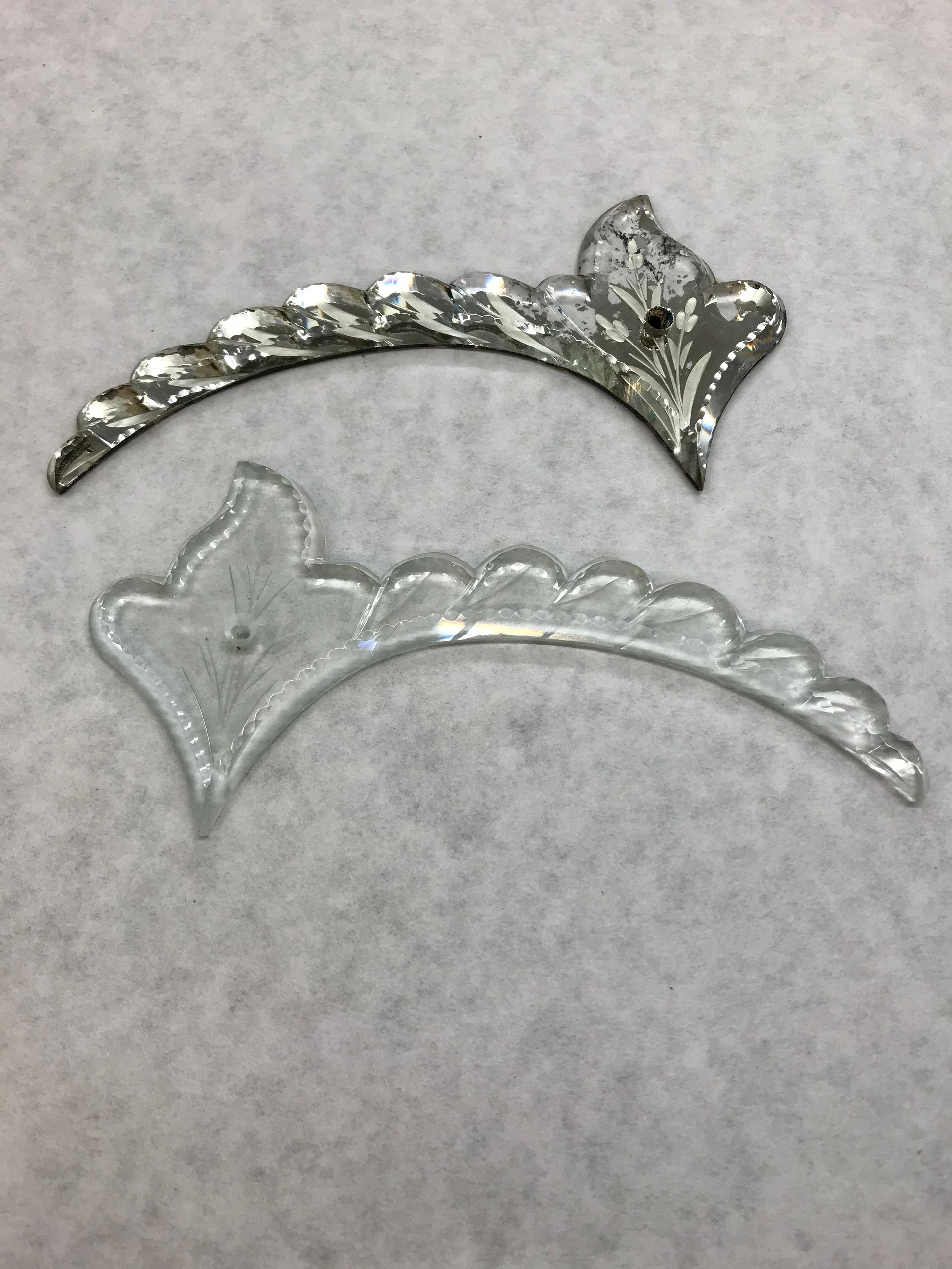 Two pieces of glass are sitting on a white surface.