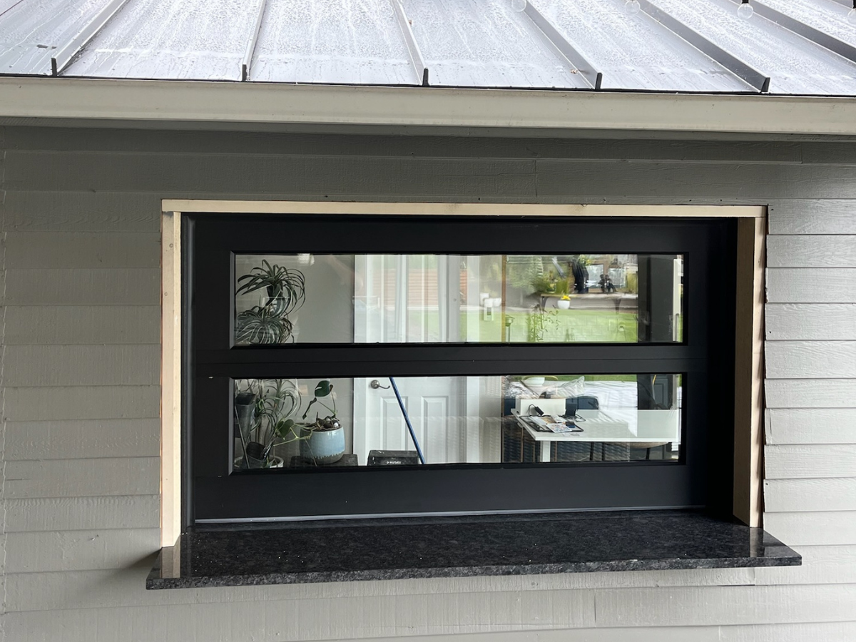 Custom garage door with black frame and horizontal glass panels