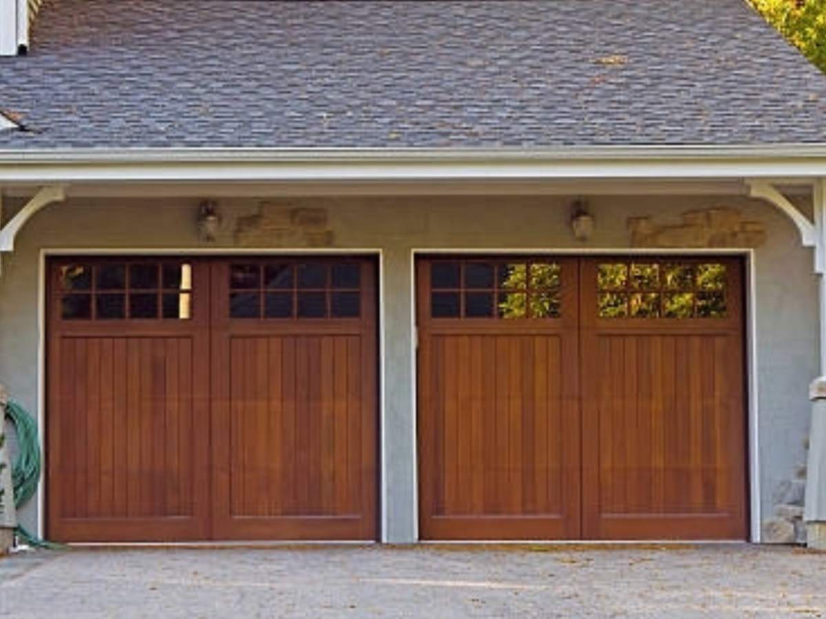 Custom wood carriage house garage doors with decorative window inserts