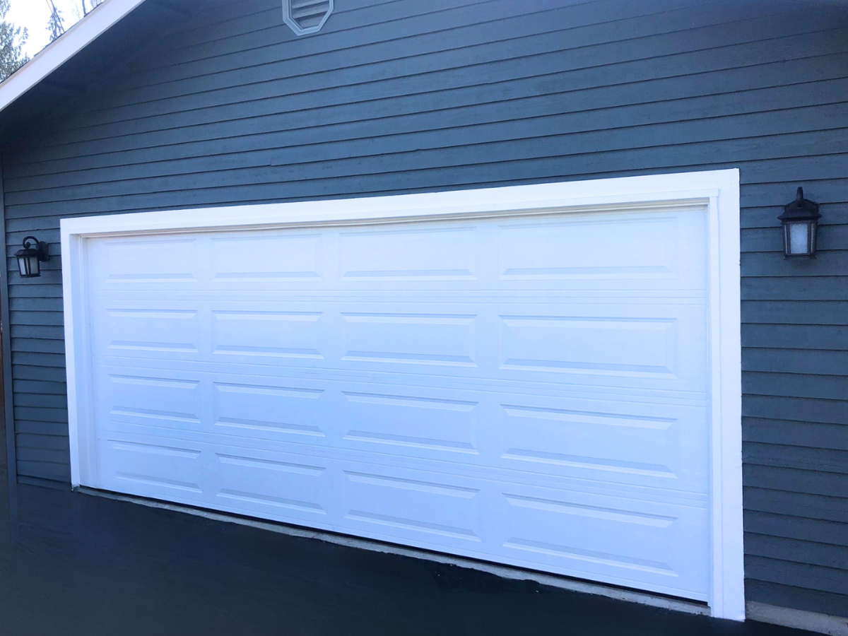 White steel garage door installation on residential home with horizontal panel design