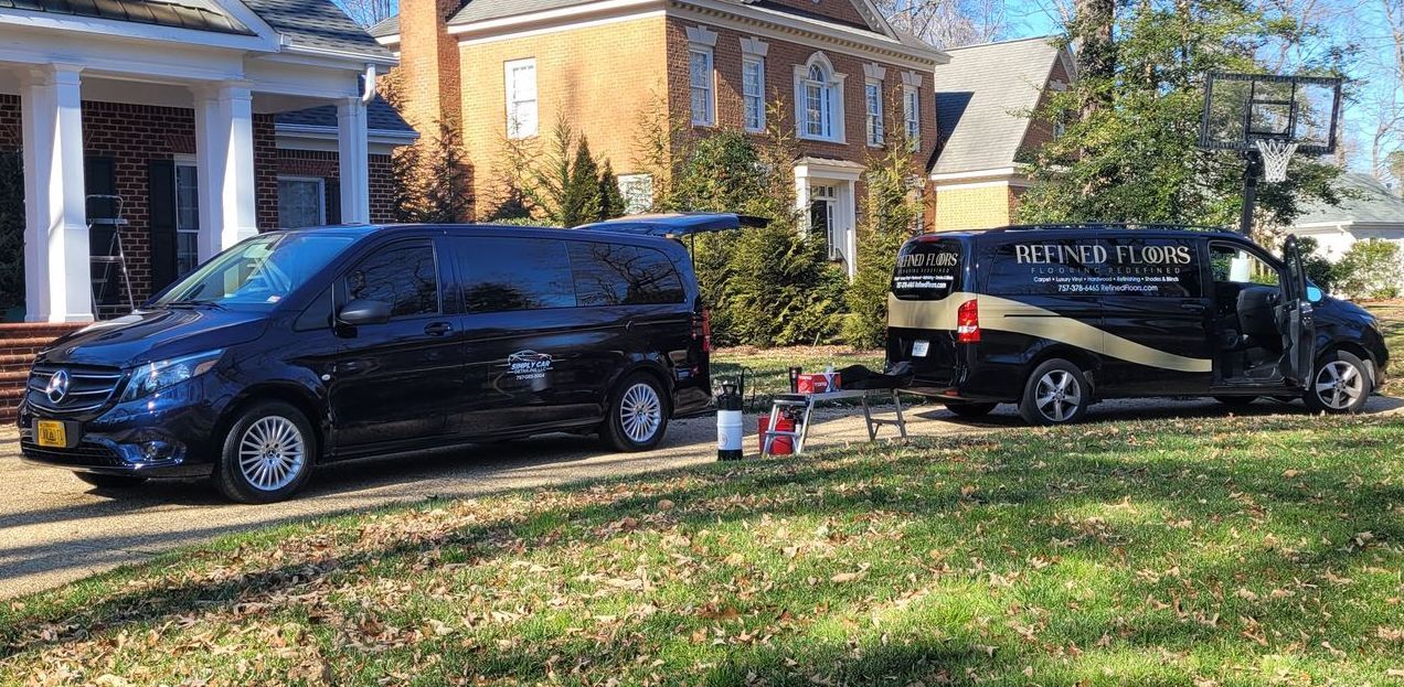 Two vans are parked in front of a house.
