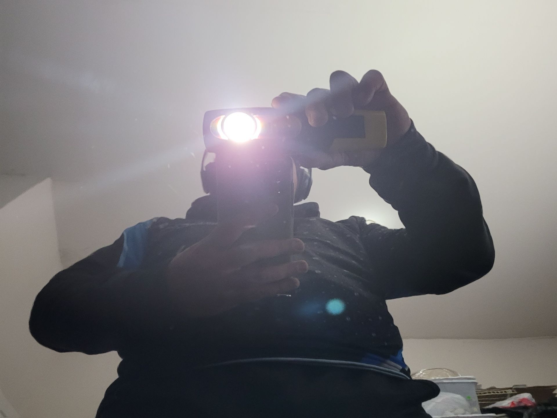 A man is taking a picture of himself with a flashlight
