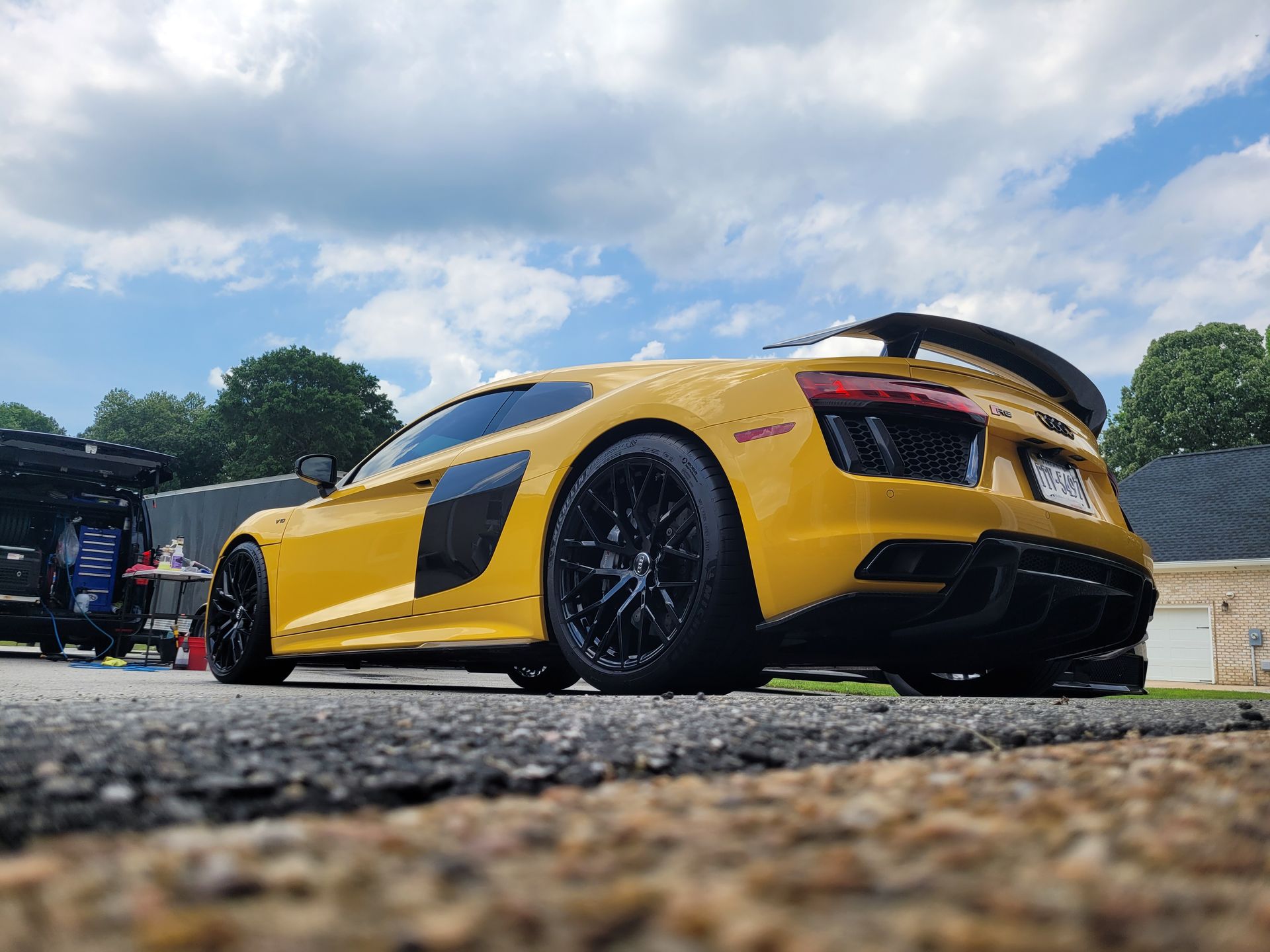 A yellow R8 2017 sports car is parked on the side of the road.