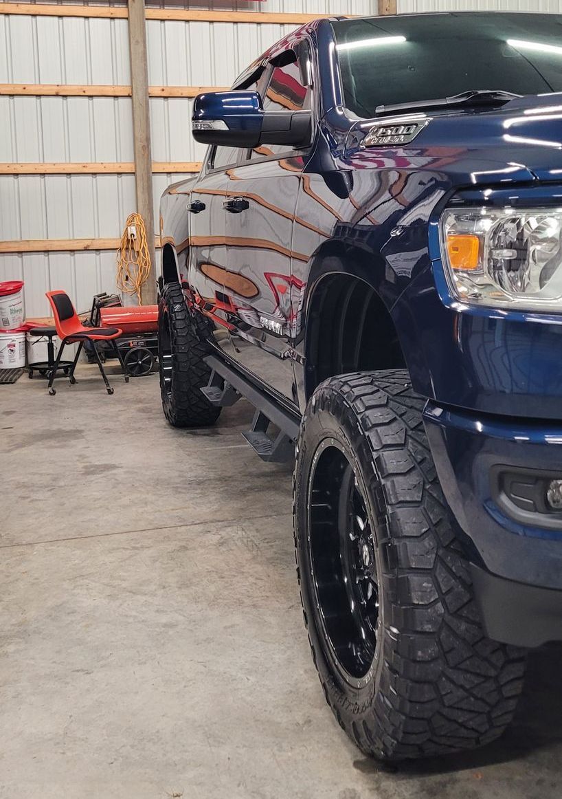 A RAM 1500 2019 with black tires is parked in a garage.