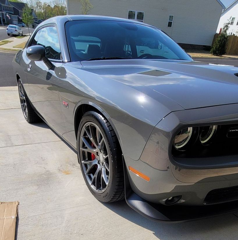 A gray dodge challenger is parked in a driveway