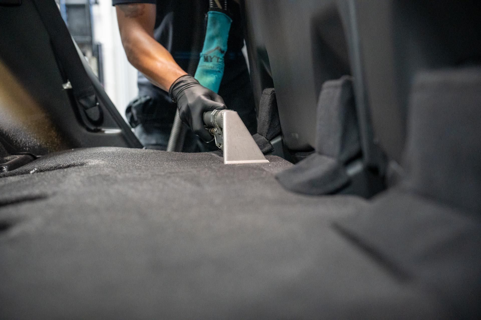 A man is removing dust and hair from a folded down seat