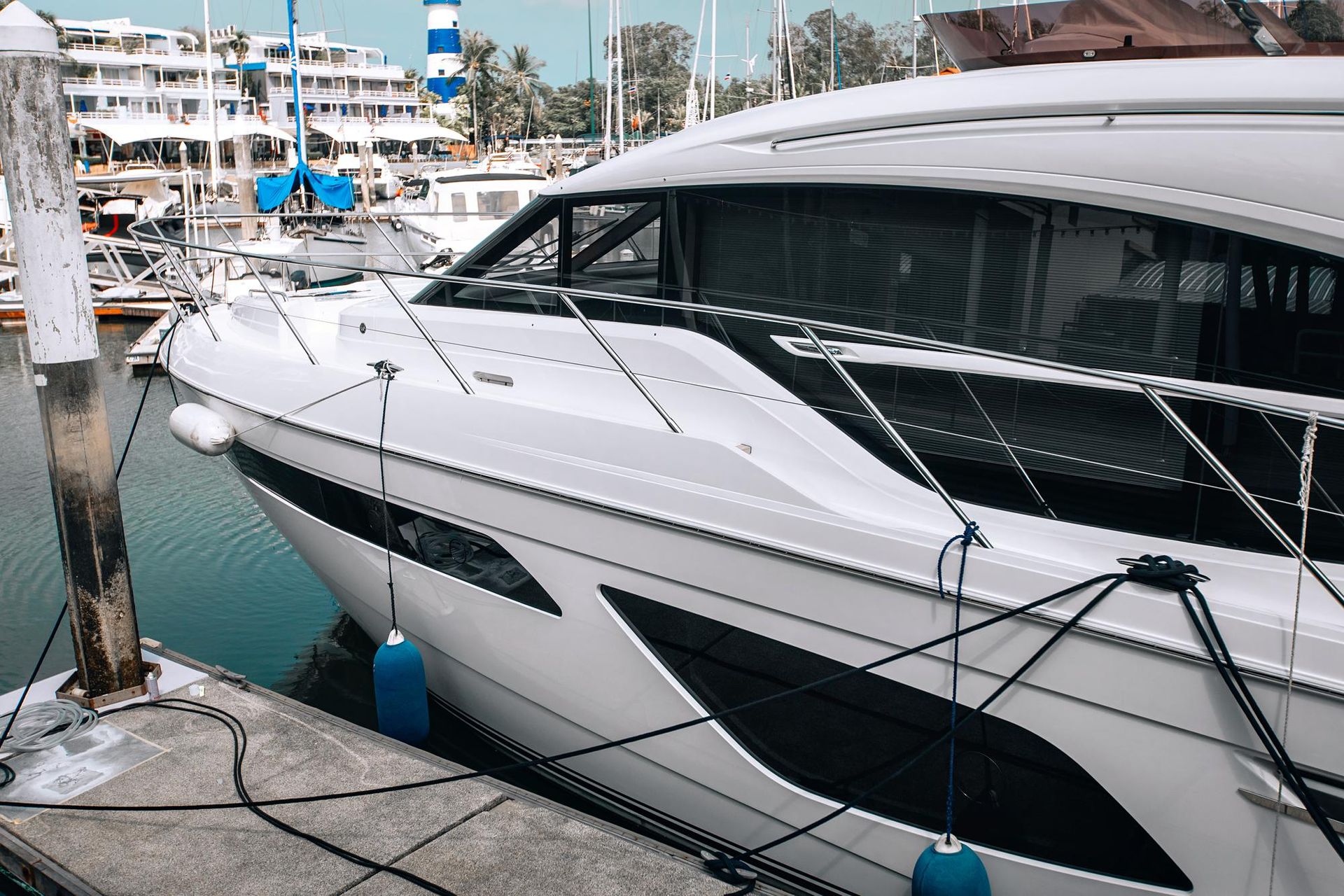 A large white yacht is docked at a marina