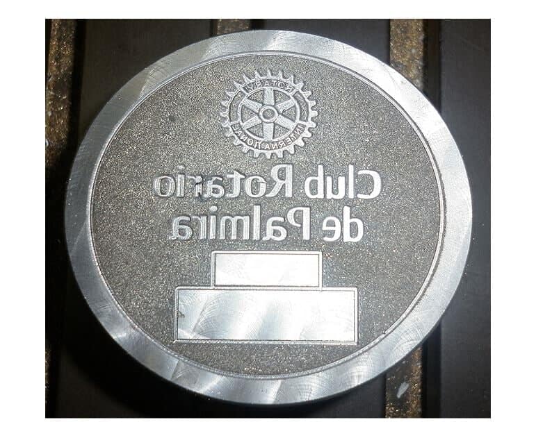 Placa metálica circular con el logotipo del Rotary Club y la inscripción 
