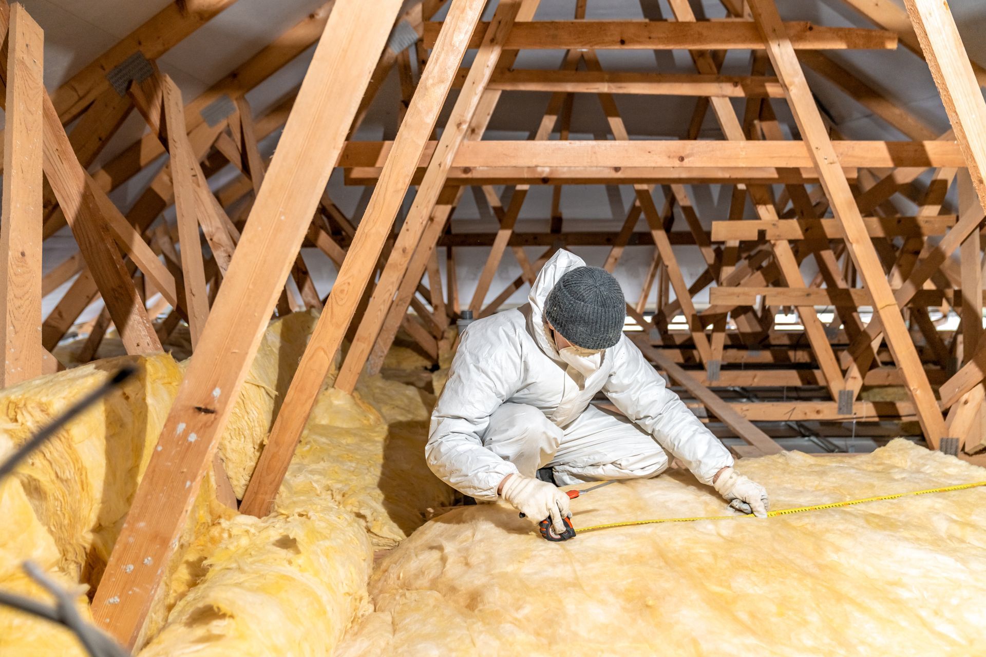 Full service home insulation contractor measuring attic insulation