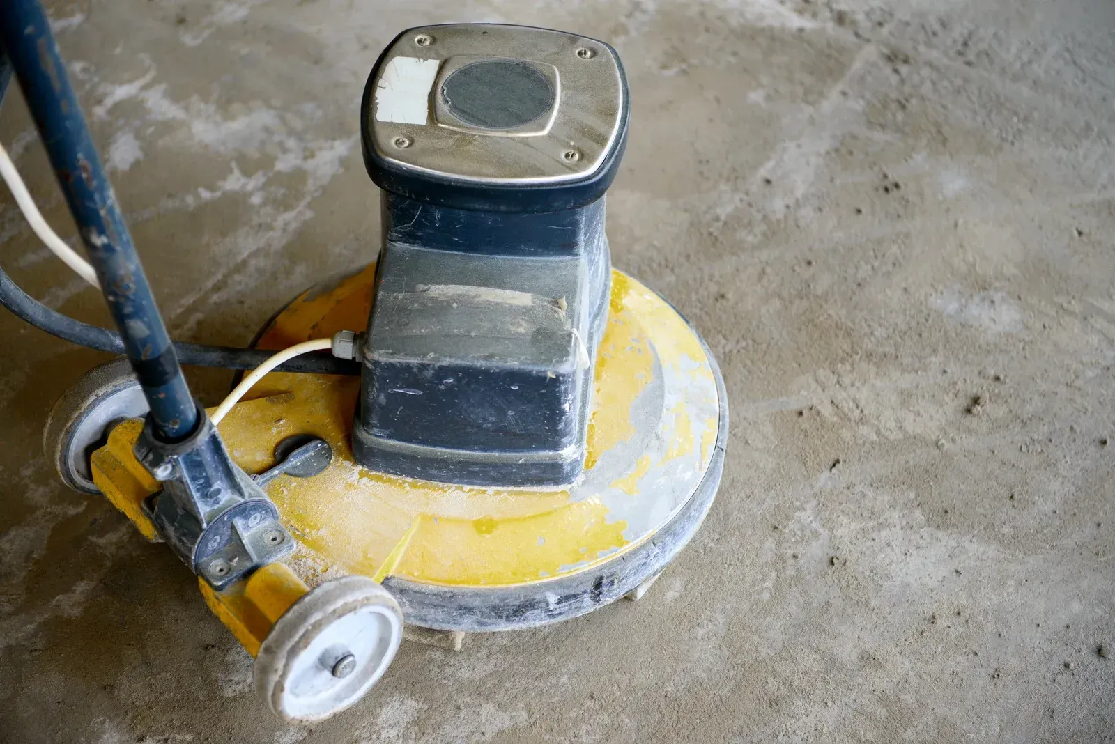 A yellow and black machine is sitting on a concrete floor.