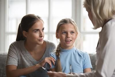 A mother and daughter are talking to a doctor.