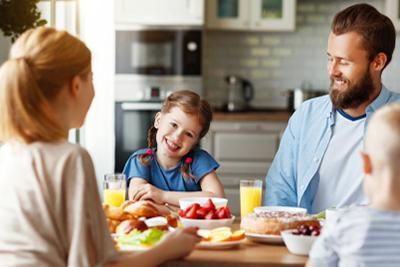 A family is sitting at a table eating breakfast together.