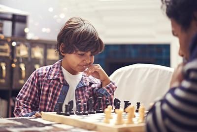 A man and a boy are playing a game of chess.
