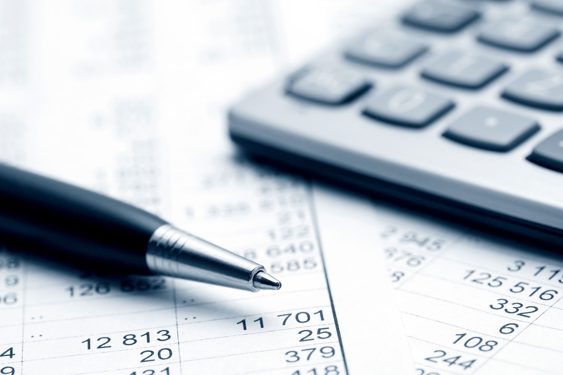 Close-up of a pen, calculator, and financial documents with numbers. Close-up of a pen, calculator, and financial documents with numbers.
