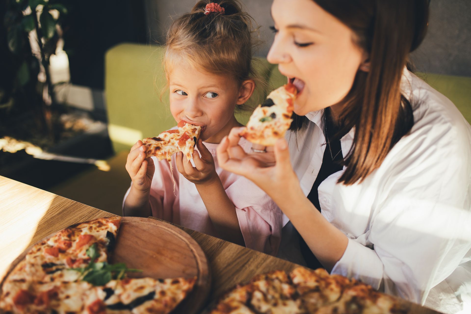 Mom and daughter eating pizza