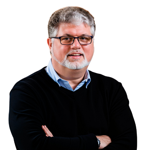 Portrait of a smiling man with glasses and crossed arms, wearing a black sweater over a blue shirt