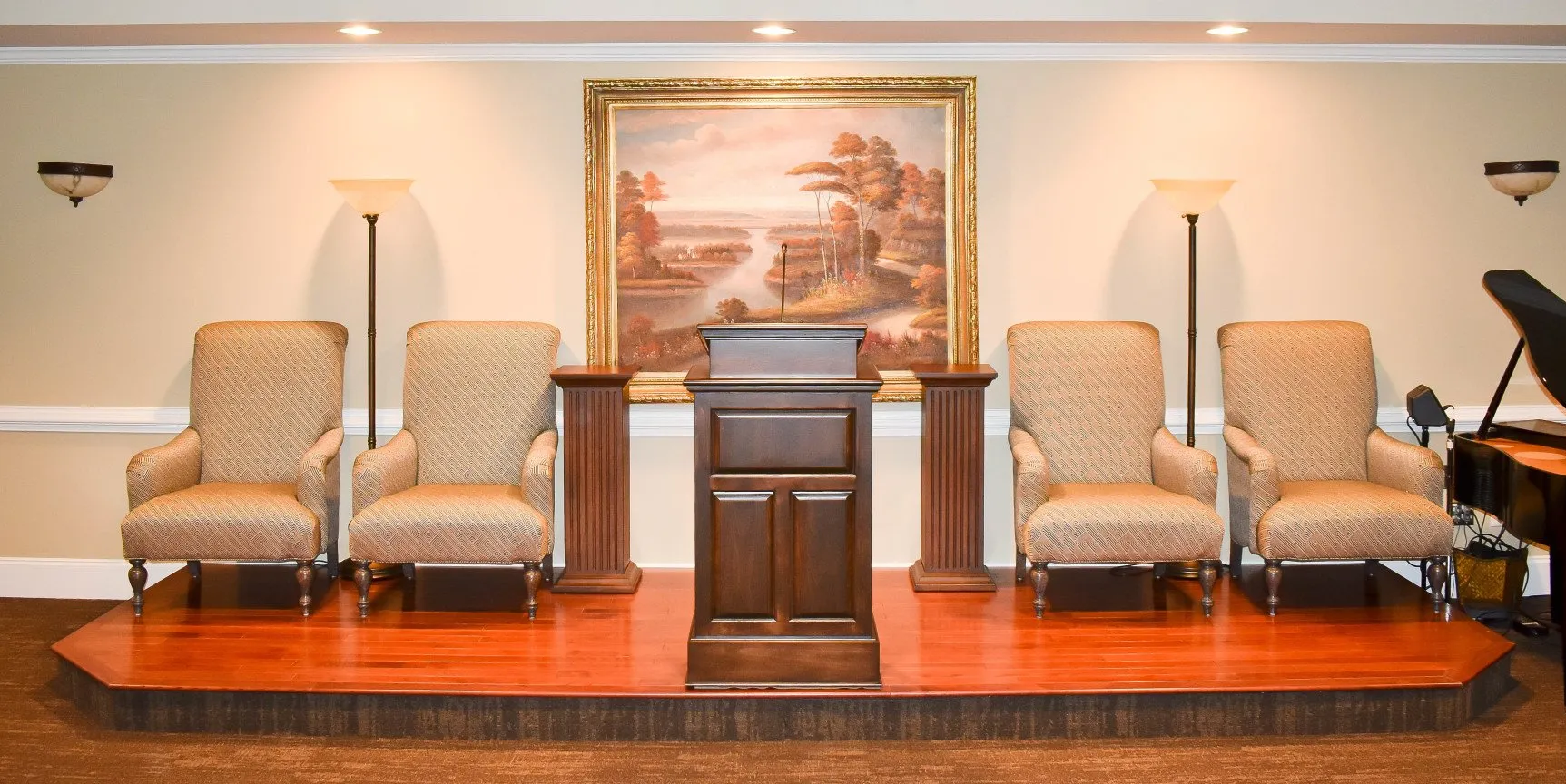 A room with a podium and chairs and a piano