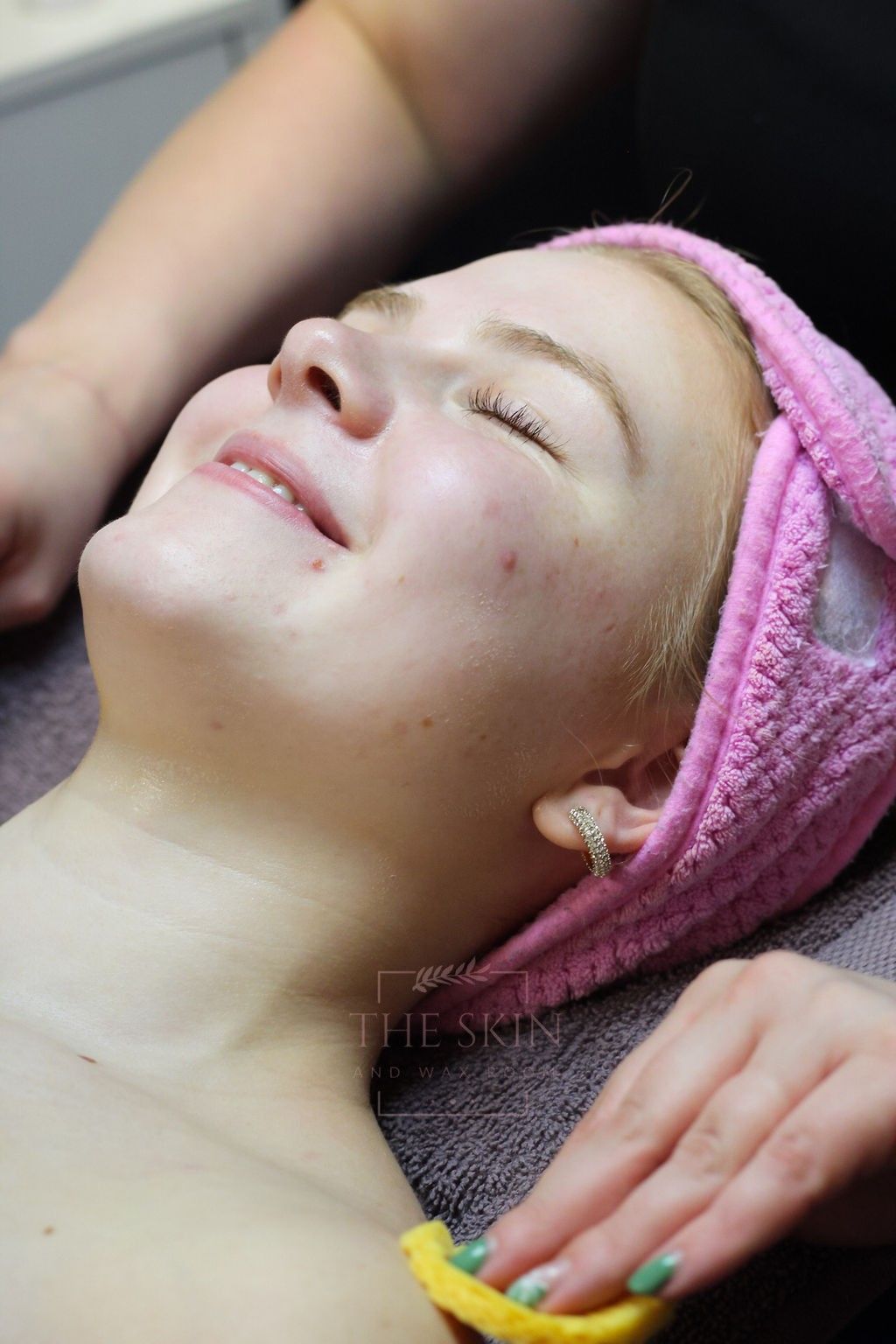 A woman is getting a facial treatment at a beauty salon.