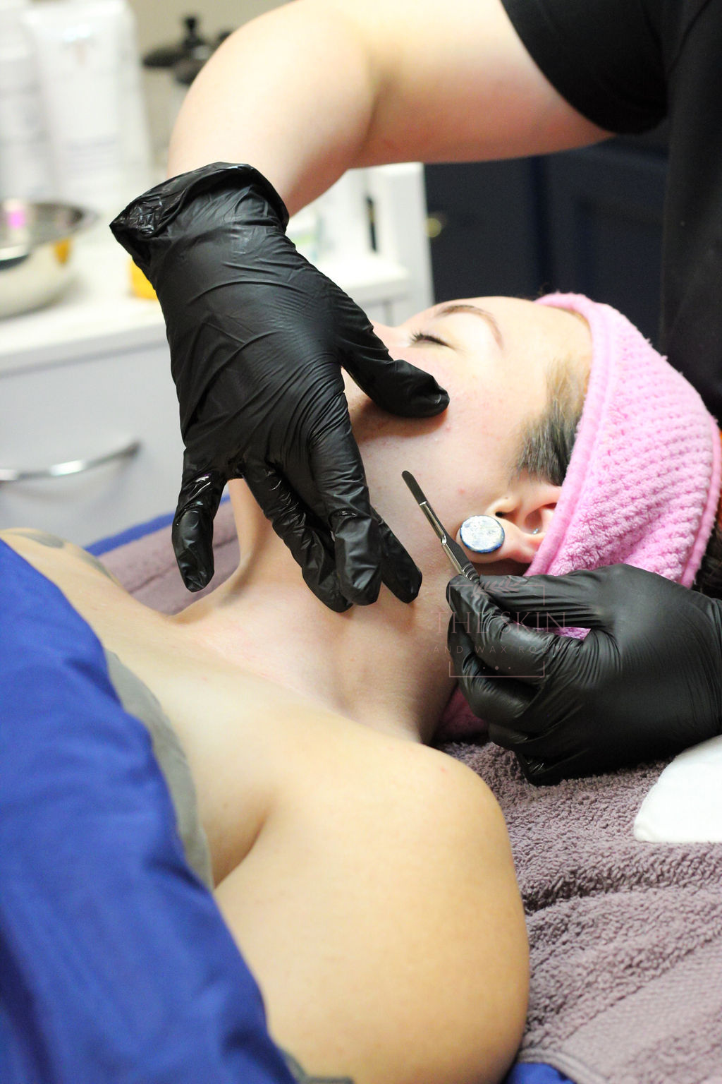 A woman is getting her eyebrows waxed in a beauty salon.