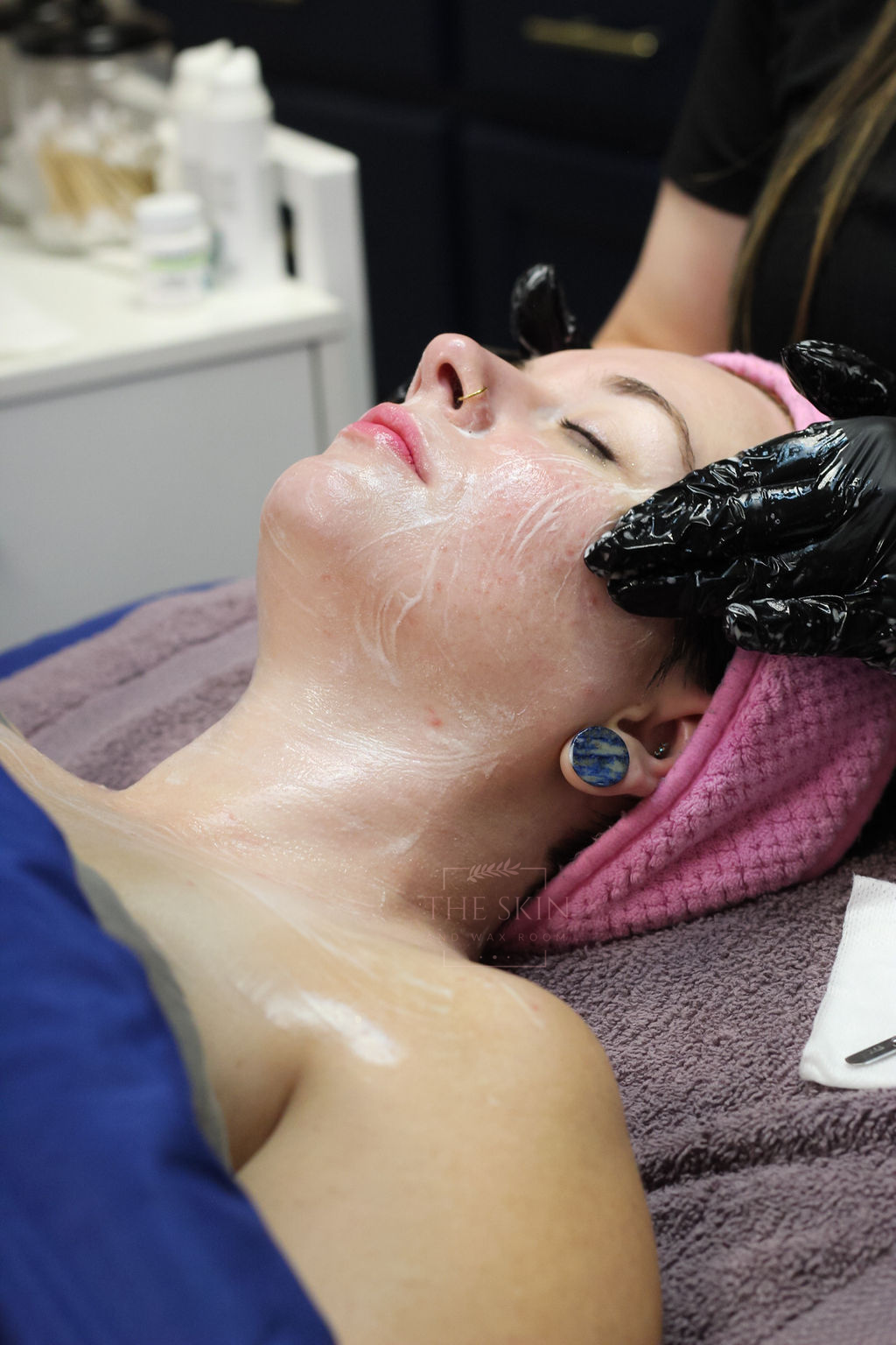 A woman is getting a facial treatment at a spa.