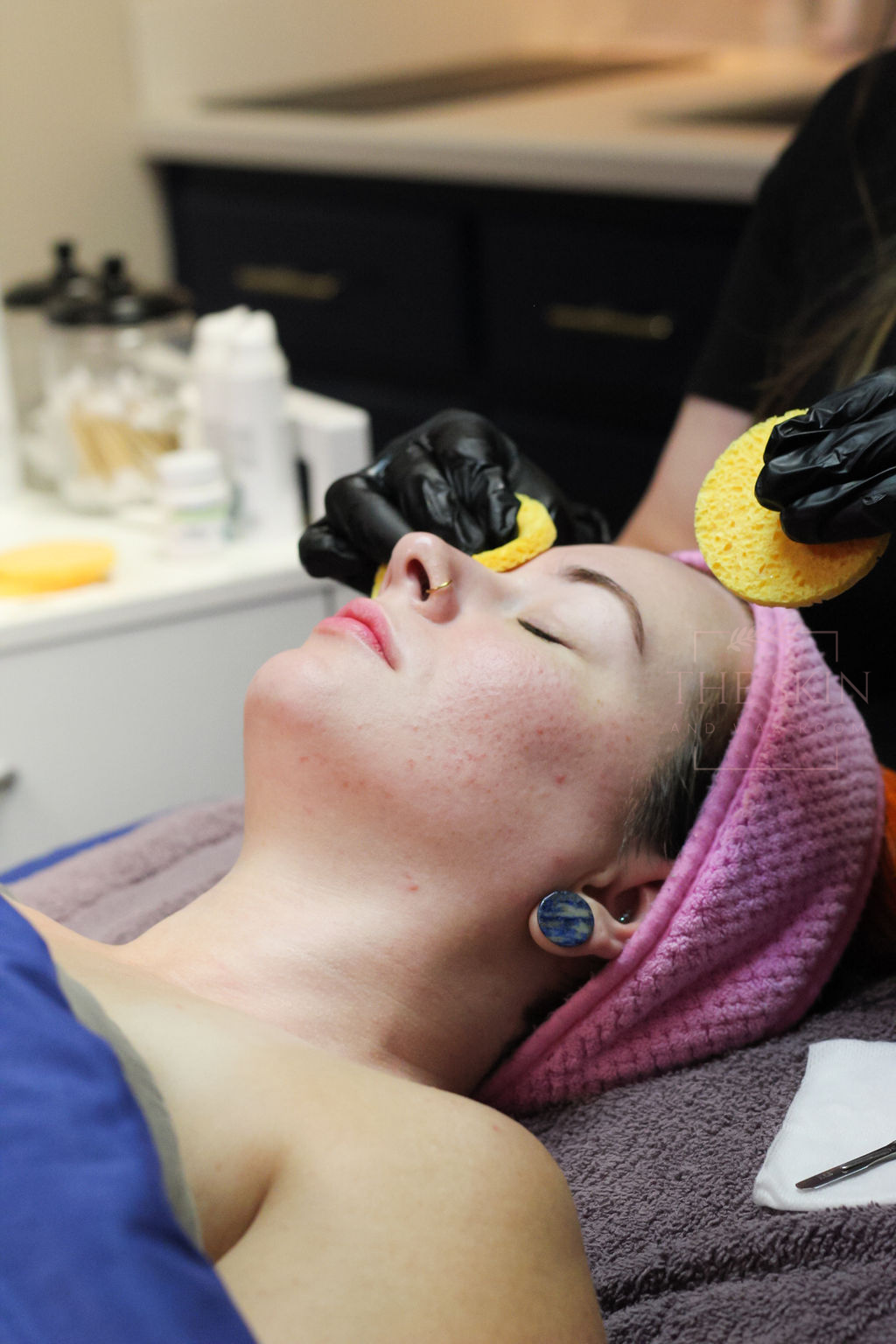 A woman is applying mascara to her eyebrows.