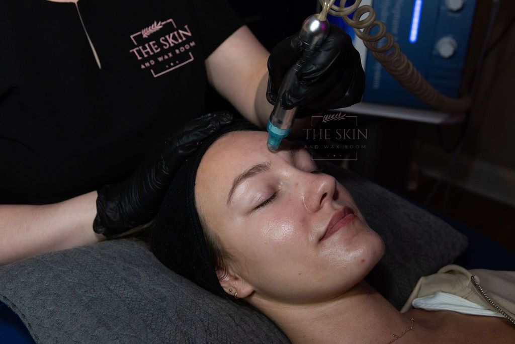 A woman is getting an ultrasound treatment on her face.