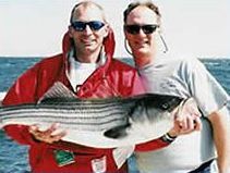 The Captain and a fisherman holding. large rock fish