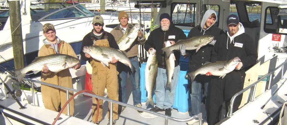 A group of men standing on the Taurus holding fish